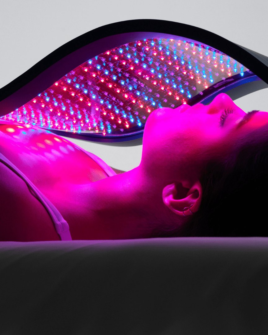 A Celluma LED light therapy panel in use over a client’s face and chest